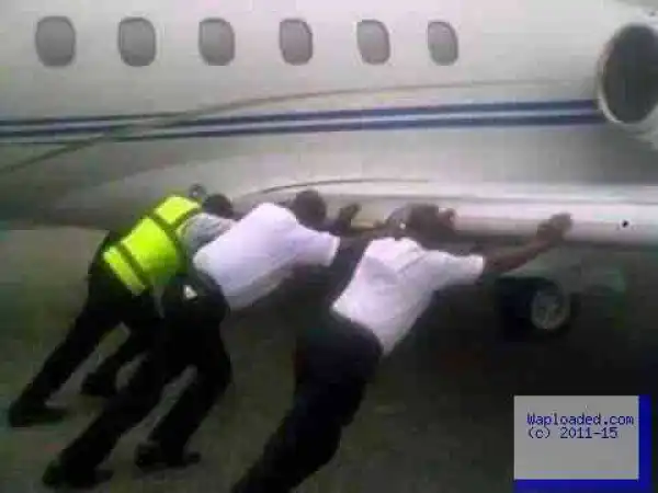 Photo: Airport Officials Pushing An Aeroplane